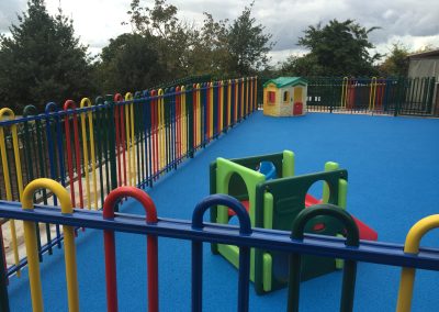 2D143543-C693-4AEA-AE89-7EC45923C8B3 Civils and groundworks. Play area blue coloured surfacing with coloured fencing.