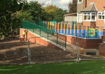 ADEC2CDE-449F-4D36-A42F-B41B512590ED Civils and groundworks. Play area surfacing with wall and fencing.